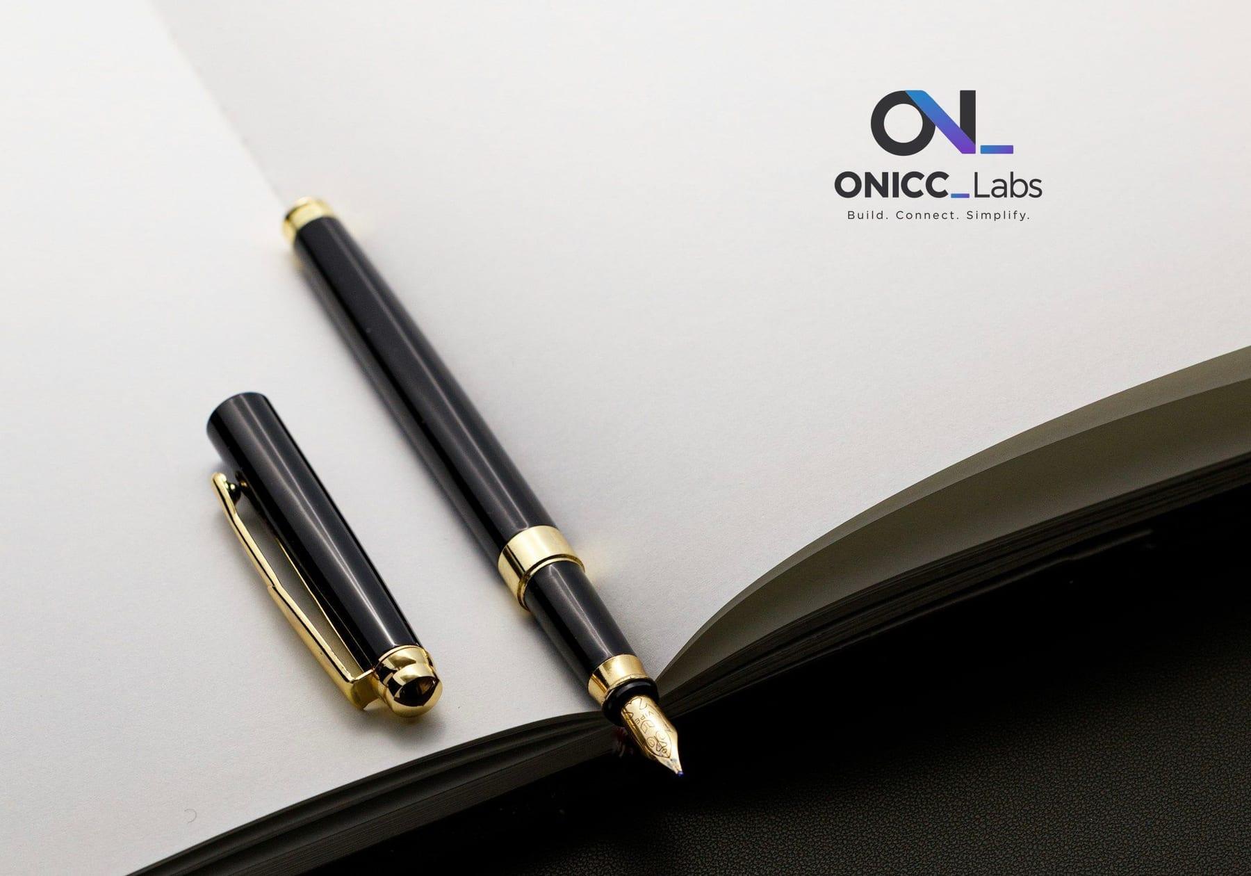 Black and gold fountain pen on a notebook page printed with the ONICC Labs logo