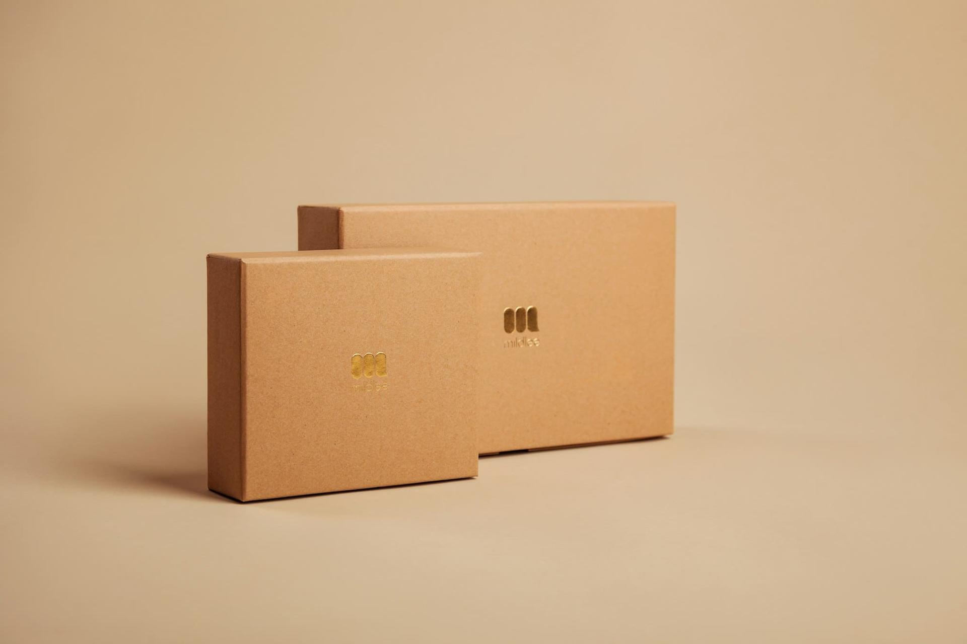 A pair of kraft-board presentation boxes with a debossed mark