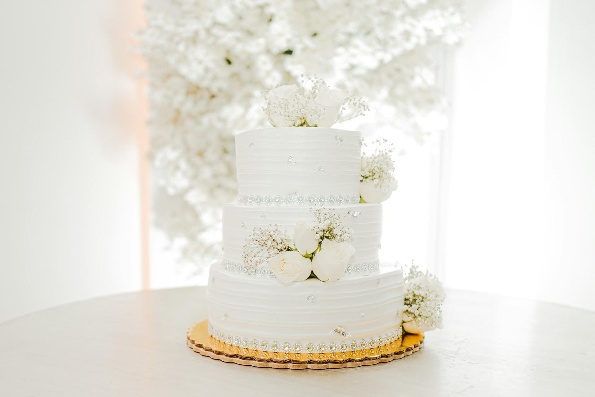 A three-tier white cake decorated with fresh flowers