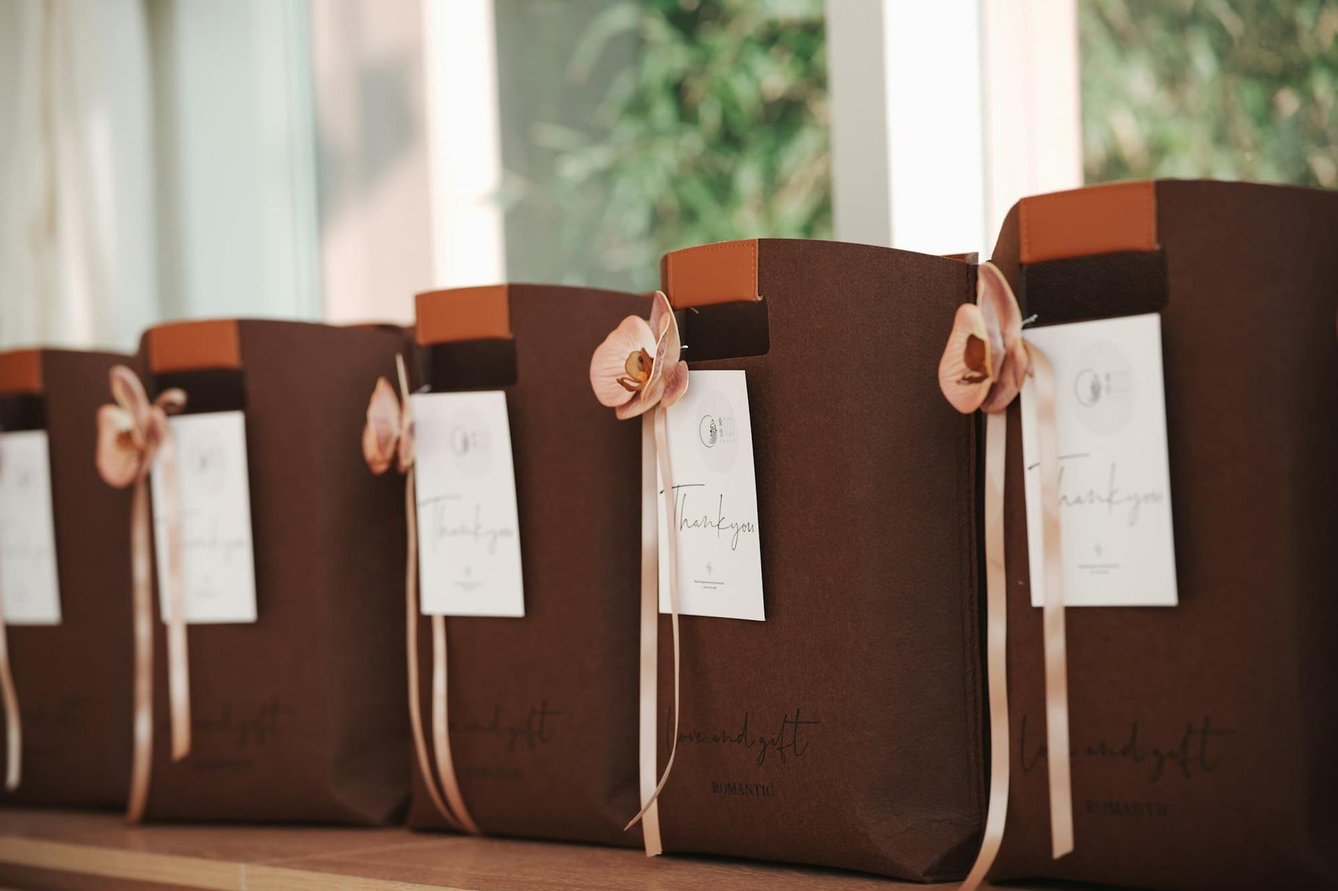 A row of welcome gift bags with ribbons and thank-you tags
